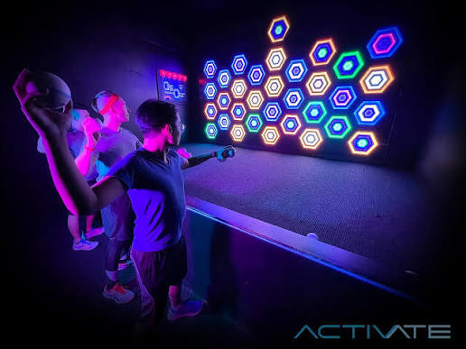 Players aiming soft balls at a reactive Arena wall