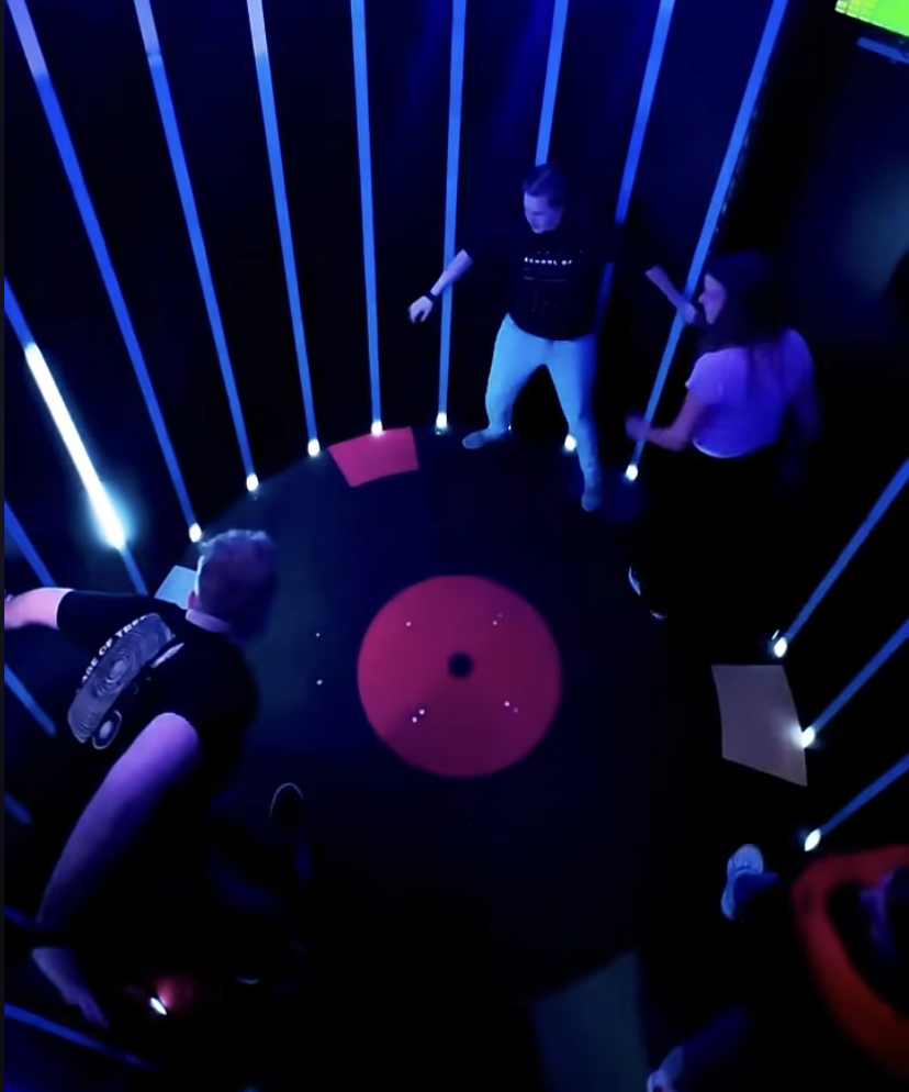Players reacting to light prompts inside the circular Rolling room